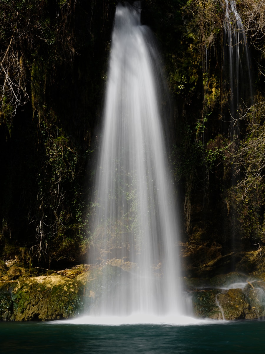 a very tall waterfall in the middle of a forest